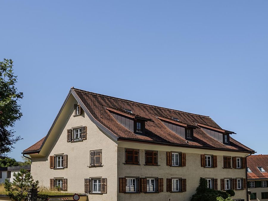 Mehrfamilienhaus aus den 1950er-Jahren mit steilem Ziegeldach und ausgebautem Dachgeschoss