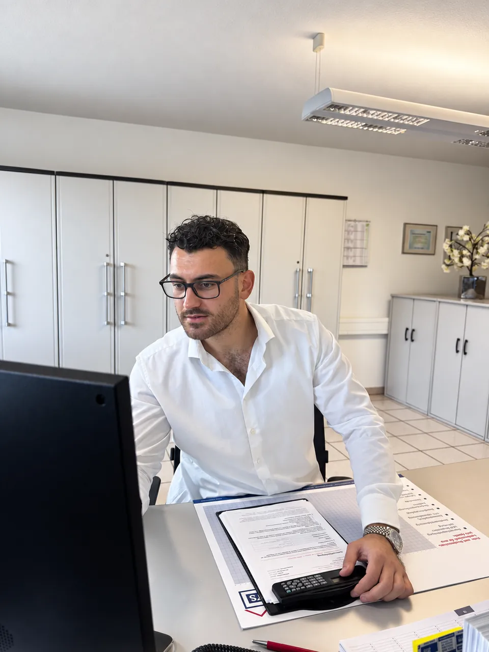 Vito Donnarumma arbeitet mit Objektunterlagen am Computer